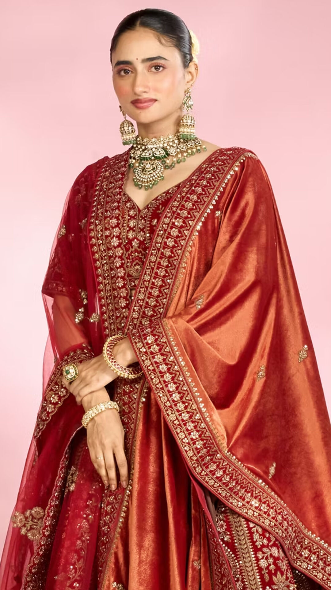Woman in a deep red embroidered lehenga with heavy gold jewellery styled for Durga Puja festive celebrations